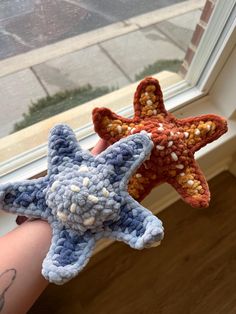 two crocheted starfishs sitting next to each other on a window sill