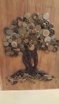 a tree made out of buttons and chains on a wooden paneled wall, with the roots