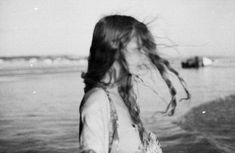 a woman standing in the water with long hair