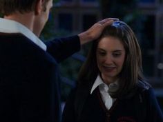 a woman getting her hair combed by a man in a black jacket and white shirt