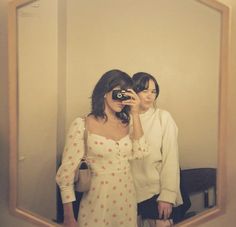 two women are standing in front of a mirror