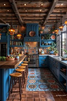 a kitchen with blue cabinets and wooden floors, an island countertop and stools