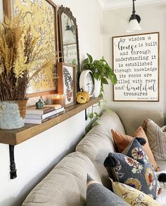 a living room filled with lots of furniture next to a wall mounted clock and framed pictures