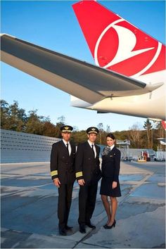 two pilots standing next to each other in front of an airplane