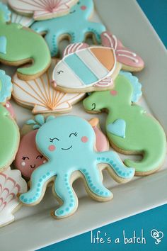 some decorated cookies are on a white plate