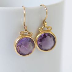 "𝗪𝗔𝗡𝗧 𝟭𝟬% 𝗢𝗙𝗙 𝗧𝗢𝗗𝗔𝗬? Get your code at https://bit.ly/2Jlkfoz (Just copy and paste that into your browser.). --------------------------------------------------------------- Elegant 18k gold round dangle earrings with round faceted amethyst pendants. The settings encircle the gemstones delicately so that the light can travel through them and reveal the beauty of the purple color. They have great movement and will definitely be an asset to every outfit. Amethysts have always had a par Round Purple Earrings With Gemstone Accents, Purple Gemstone Accented Round Earrings, Purple Round Earrings With Gemstone Accents, Purple Gemstone Accent Round Earrings, Gold Amethyst Round Earrings, Gold Amethyst Earrings With Gemstone Accents, Silver Cuff Ring, Handmade Wedding Rings, Drop Earrings Gold