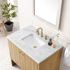 a bathroom with a marble sink and wooden cabinet in front of a mirror on the wall