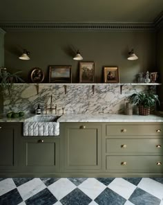 a kitchen with marble counter tops and green cabinets