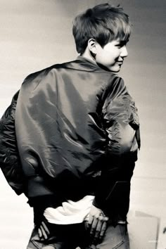 black and white photograph of a woman with her back to the camera, wearing a leather jacket