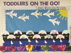 a bulletin board with paper airplanes and watercolors