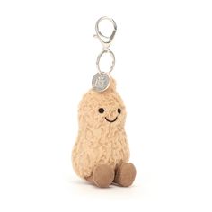 a small stuffed animal with a coin on it's keychain, sitting against a white background