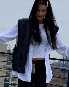 a woman standing on top of a roof with her arms outstretched