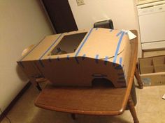 an open box sitting on top of a wooden chair with blue tape around it's edges