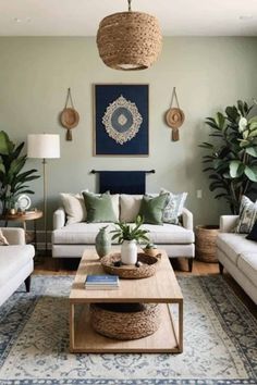 a living room filled with white couches and lots of greenery on the walls