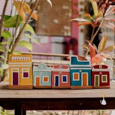 a wooden toy train sitting on top of a table next to some potted plants