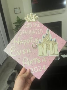 someone is holding up a pink graduation cap