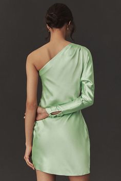 Rendered in stretch polyester satin, this sleek dress is sure to turn heads. The unique one-shoulder design paired with a sophisticated long sleeve offers an intriguing blend of elegance and subtle allure. Ruched detailing at the hip enhances the shape with a touch of sculptural artistry to the overall silhouette. | Lucy Stretch Satin One-Shoulder Mini Dress by BHLDN in Green, Women's, Size: 16, Polyester/Satin at Anthropologie Fitted One Shoulder Dress With Satin Finish For Party, Fitted One-shoulder Satin Dress For Night Out, Fitted One-shoulder Dress With Satin Finish And Asymmetrical Neckline, Glamorous Fitted Satin One Shoulder Dress, Glamorous Fitted Satin One-shoulder Dress, Glamorous Satin One-shoulder Fitted Dress, Fitted One-shoulder Satin Dress, Fitted One-shoulder Satin Cocktail Dress, Fitted Satin One Shoulder Cocktail Dress