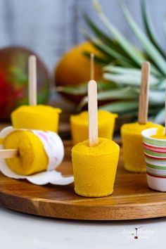 popsicles made out of felt are sitting on a wooden tray next to oranges