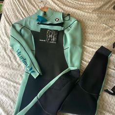 a wet suit and boot laying on top of a bed