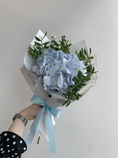 a person holding a bouquet of blue flowers