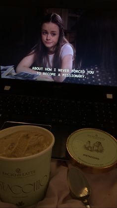 a cup of coffee sitting on top of a laptop computer