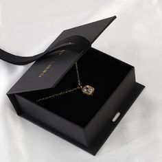 an open black box with a necklace in it