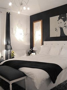 black and white bedroom with chandelier, large bed and painting on the wall