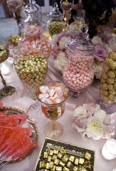 a table topped with lots of candy and candies next to other desserts on plates