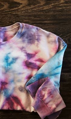 a tie dye shirt sitting on top of a wooden table