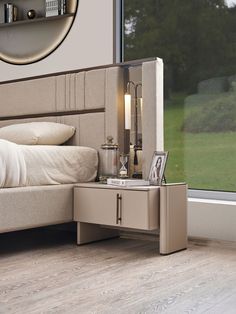 a bed sitting next to a window with a mirror on it's side table