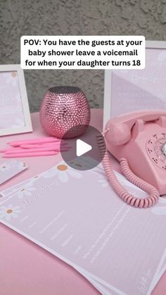 a pink phone sitting on top of a table next to some papers and other items