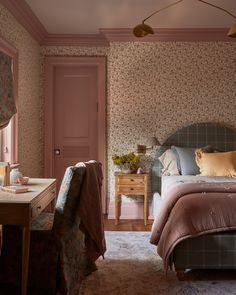 a bedroom with pink walls and floral wallpaper