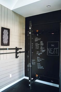 there is a chalkboard on the wall next to some metal bars in this room