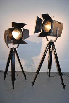 two spotlights on tripod lights in front of a white wall