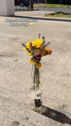 a vase filled with yellow flowers sitting on top of a parking lot