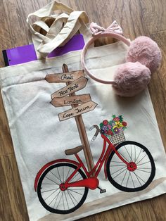 a tote bag with a bicycle on it and a pink pom - pom