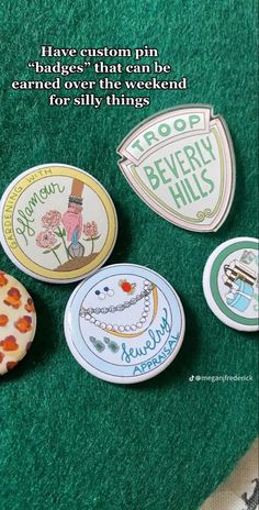 four different badges are sitting on a green surface with the words, have custom pin badges that can be customized for every thing