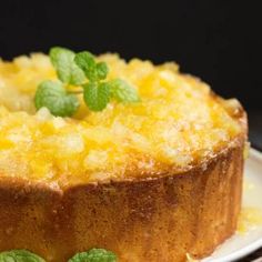 a close up of a cake on a plate with green leaves and mint sprigs