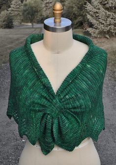 a mannequin wearing a green sweater with a bow