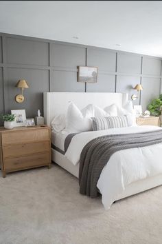 a bedroom with a bed, nightstands and two lamps on either side of the bed