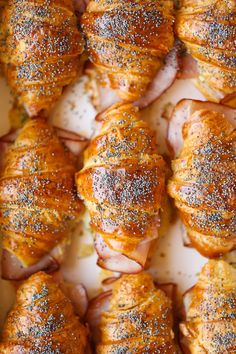 ham and cheese wrapped in puff pastry on a baking sheet with sprinkles