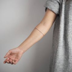 a woman's arm with a small tattoo on the left side of her arm