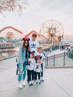 a family poses for a photo in front of an amusement park