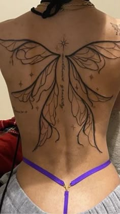 the back of a woman's body with tattoos on her upper and lower back