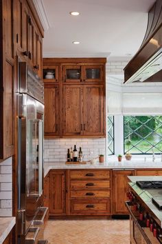 a kitchen with wooden cabinets and marble counter tops