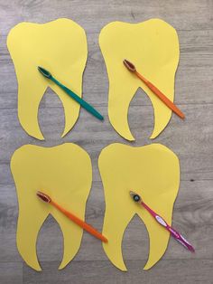 four pieces of paper cut out to look like toothbrushes and dental floss