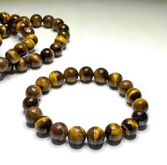 Tiger Eye Crystal Bracelet, Tiger Eye Gemstone Beaded Bracelet  You will receive 1 (ONE) Tiger Eye Bead Bracelet similar to the items pictured  Item Description: Stone: Tiger Eye  Bead Shape: Round Beads Bead Size: 4mm, 6mm, 8mm and 10mm (choose from drop down menu) Length: 6.5 - 7inch stretch bracelet  Closure: Tie, Knot Your stretch bracelet will be randomly selected. Great for mixing and matching with other bracelets. Great for mixing and matching with other bracelets. Tiger's eye is a popula Brown Crystal Bracelet With Gemstone Beads, Brown Beaded Round Crystal Bracelet, Eye Bead Bracelet, Tiger Eye Gemstone, Tiger Eye Jewelry, Tiger Eye Crystal, Tiger Eye Bracelet, Tigers Eye Gemstone, Tiger Eye Beads