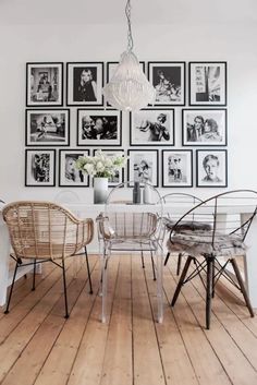 a dining room with pictures on the wall and chairs in front of it that are clear