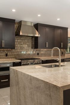 a kitchen with marble counter tops and stainless steel appliances in the center, along with dark wood cabinets