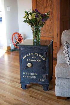 a vase with flowers sitting on top of a table next to an old fashioned machine